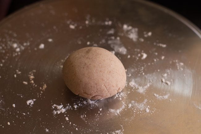 dough ball dusted with flour on a rolling board