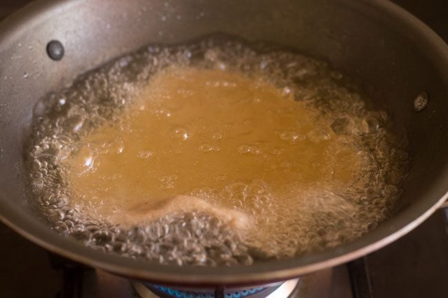 frying singhare ki poori in oil in kadai