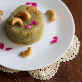 sweet potato halwa garnished with fried cashews, rose petals and served on a white colored plate.
