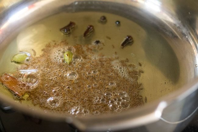 sautéing spices in hot ghee. 