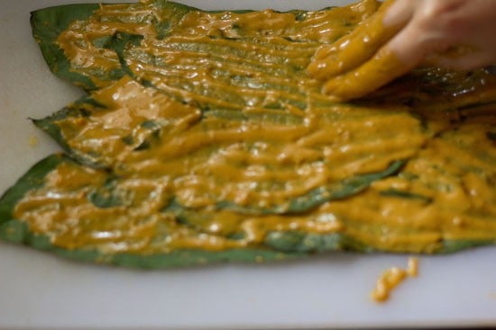 applying batter on the leaf for making pathrode. 