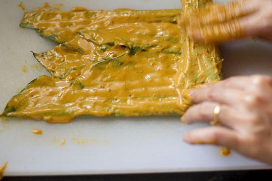 tightly rolling the leaves and applying batter for making pathrode. 