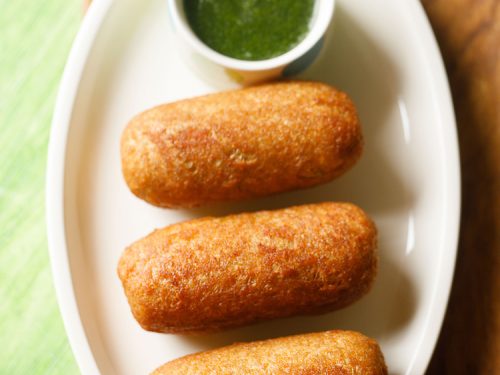 bread roll served on a white platter with a side of green chutney and text layover.