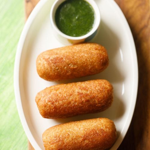 bread roll served on a white platter with a side of green chutney and text layover.