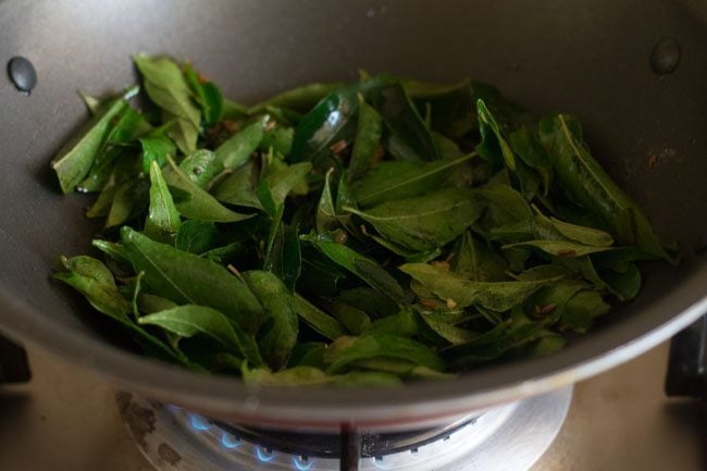frying curry leaves with spices for making kadi patta chutney. 