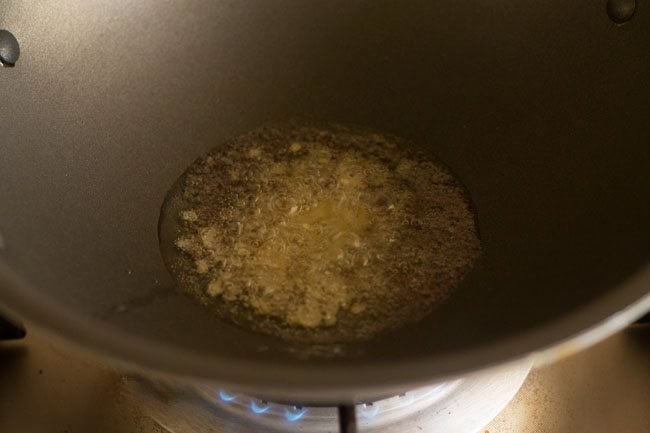 frying mustard seeds till they crackle for making kadi patta chutney. 