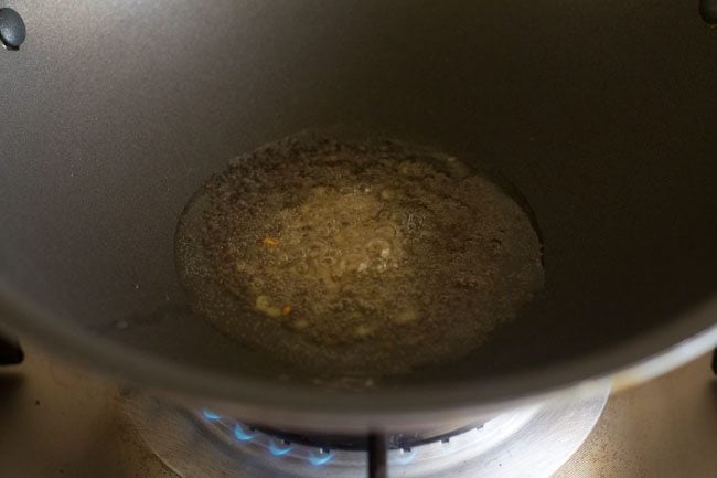 mustard seeds and black gram added to hot oil for kadi patta chutney. 