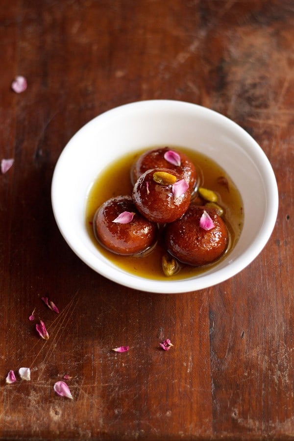 gulab jamun served in a white bowl