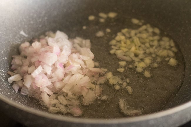 onions and garlic cloves added to oil