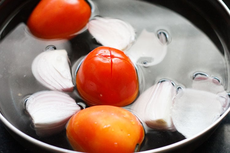 onions and tomatoes being blanched in hot water