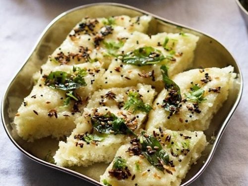 rava dhokla slices in a steel square plate.