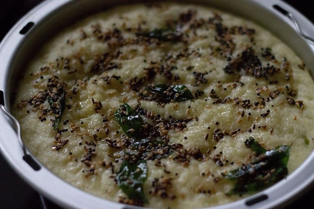 tempering mixture added to rava dhokla in the pan