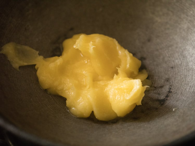 ghee added in a thick bottomed pan for rava kesari recipe. 