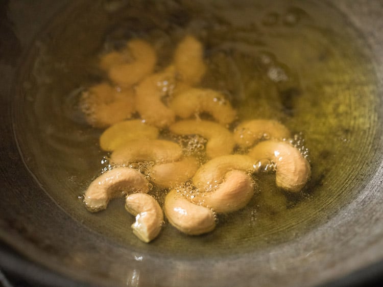 frying cashews in ghee till golden for rava kesari recipe. 