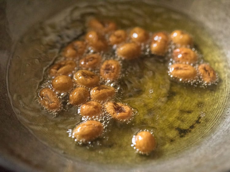 frying raisins in hot ghee for rava kesari recipe.