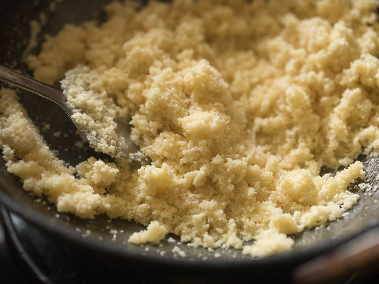 mixing rava with ghee for rava kesari recipe. 