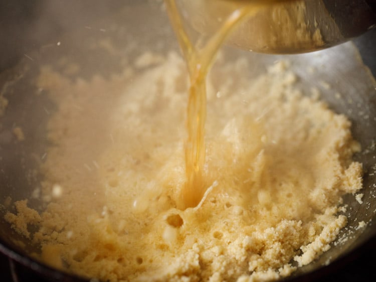 adding prepared sugar syrup to roasted rava. 