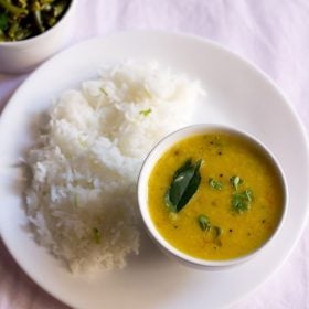 varan bhat served on a plate and bowl with a bowl of sabzi kept in the top left side.