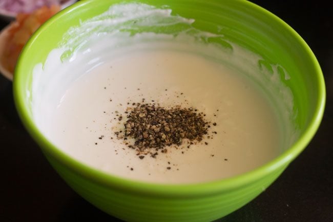 black pepper powder added to whisked curd for making mix veg raita. 