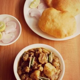 aloo chole ki sabji served in a bowl with a side of poori.