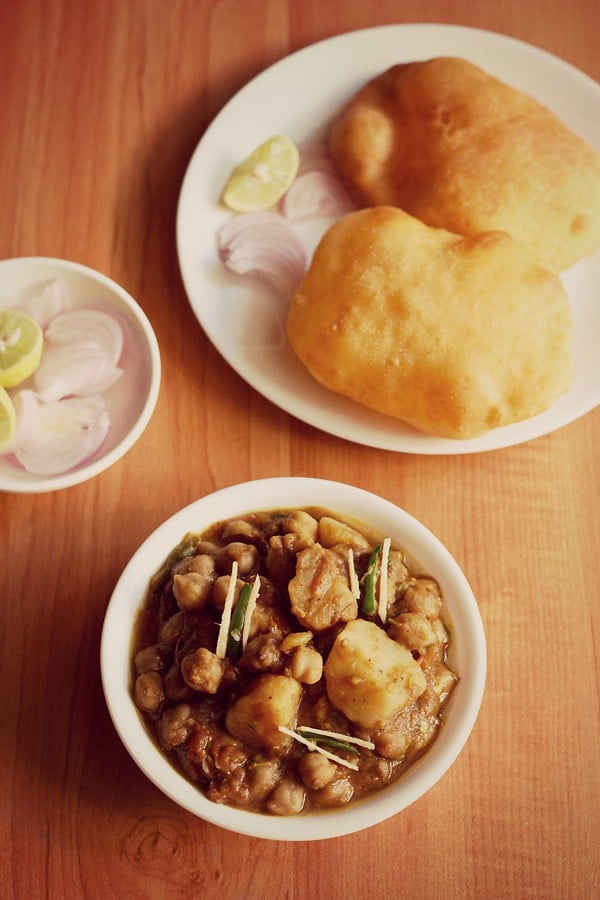 aloo chole ki sabji served in a bowl with a side of poori.