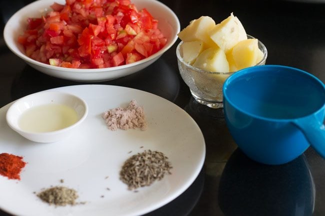 ingredients kept ready for aloo tamatar sabzi. 