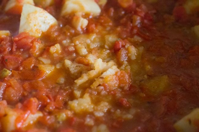 mashing potatoes in the curry. 