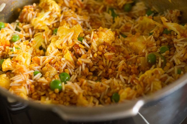 mixing rice with veggies and dal mixture