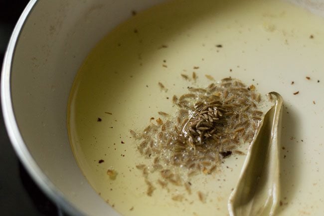 frying tej patta leaf and cumin seeds in ghee for tempering