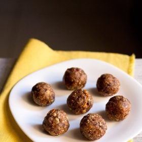 dry fruit ladoo placed on a white plate on a yellow napkin