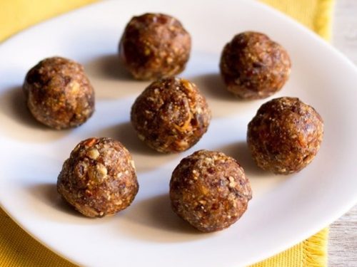 dry fruit ladoo placed on a white plate on a yellow napkin