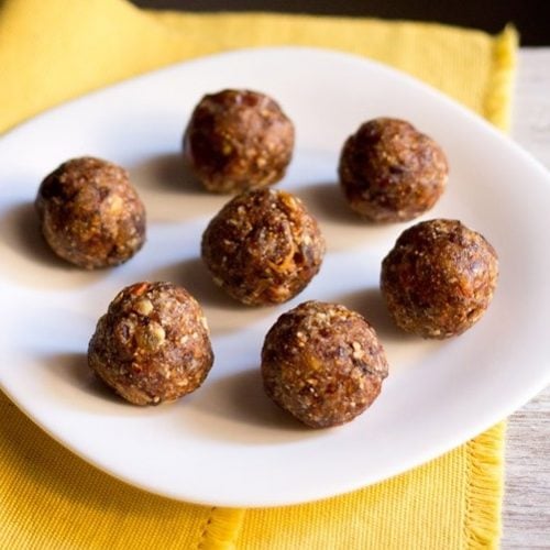 dry fruit ladoo placed on a white plate on a yellow napkin