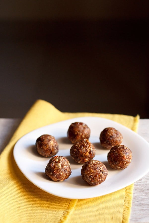 dry fruits ladoo placed on a white plate on a yellow napkin