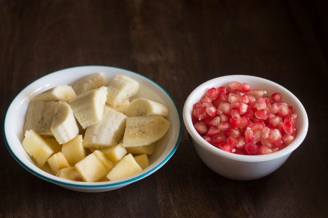 chopped apples, bananas and pomegranate arils in a bowl. 