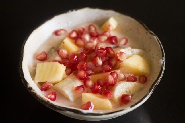 fruits added to whisked spiced yogurt. 