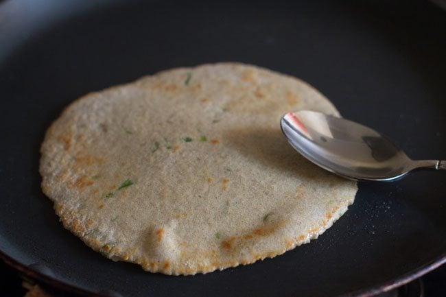 applying ghee on kuttu ka paratha