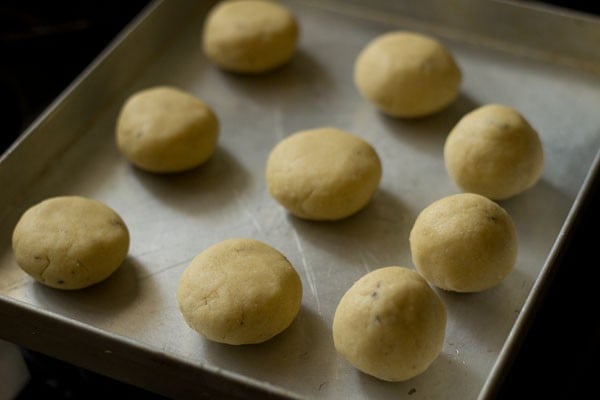 top shot of nankhatai dough portion into balls on baking sheet.