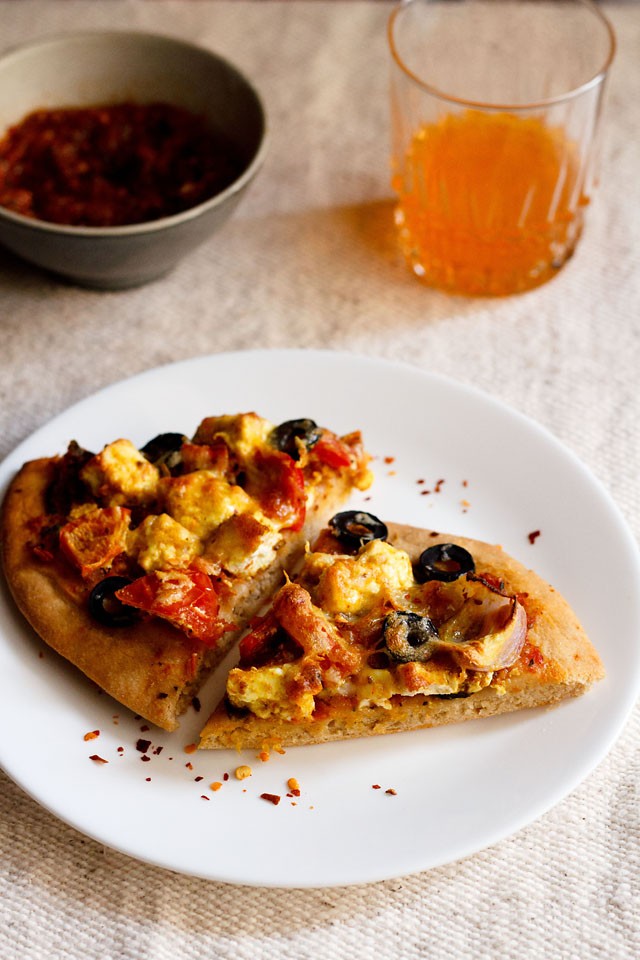 paneer tikka pizza wedges served on a white plate.