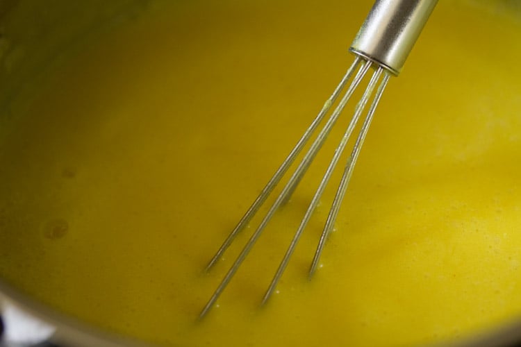 stirring and cooking rajasthani kadhi. 