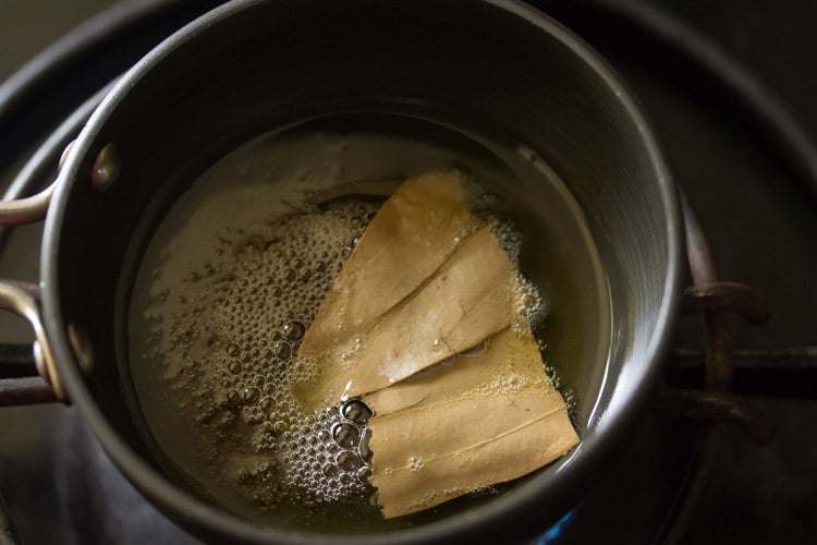 adding bay leaf to hot ghee. 