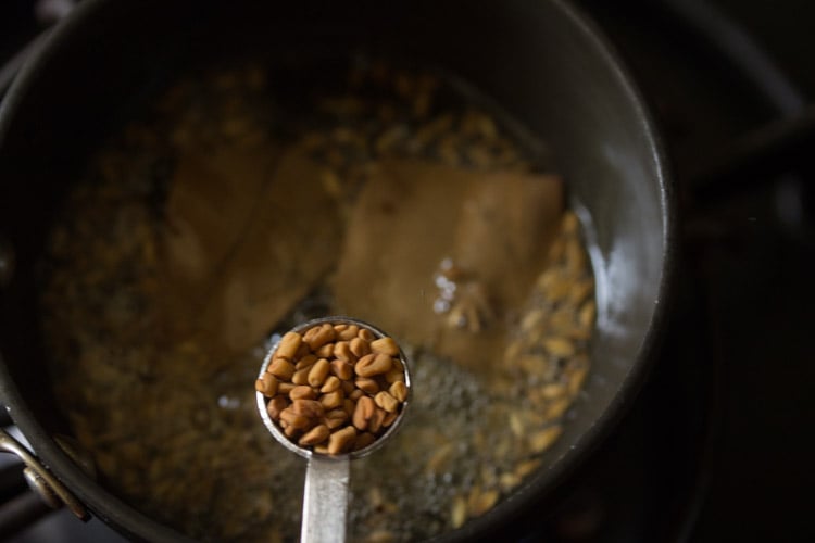 adding fenugreek seeds to the pan. 