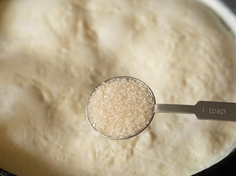 adding sugar to the pan with milk and rice grains. 