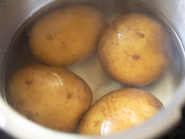 cooking potatoes in a pressure cooker for sabudana khichdi recipe. 