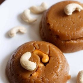 wheat halwa garnished with cashew and served on a white plate with text layover.