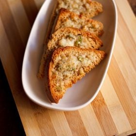 slices of cheese chilli toast on wooden board.