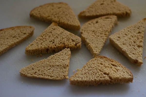 lightly toasted bread pieces on a cutting board.