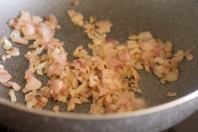 sauteing chopped onions in the kadai