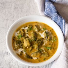 dahi bhindi served in a white bowl.