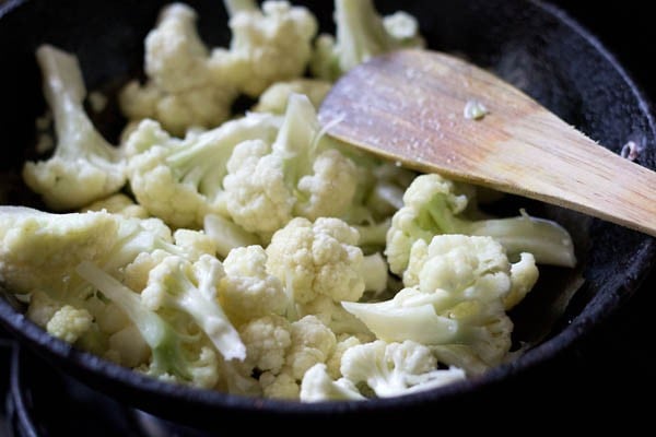 sautéing blanched gobi florets in hot oil for making cauliflower masala. 