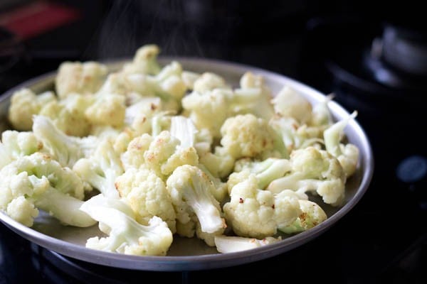 sautéed cauliflower florets on a plate for cauliflower masala. 